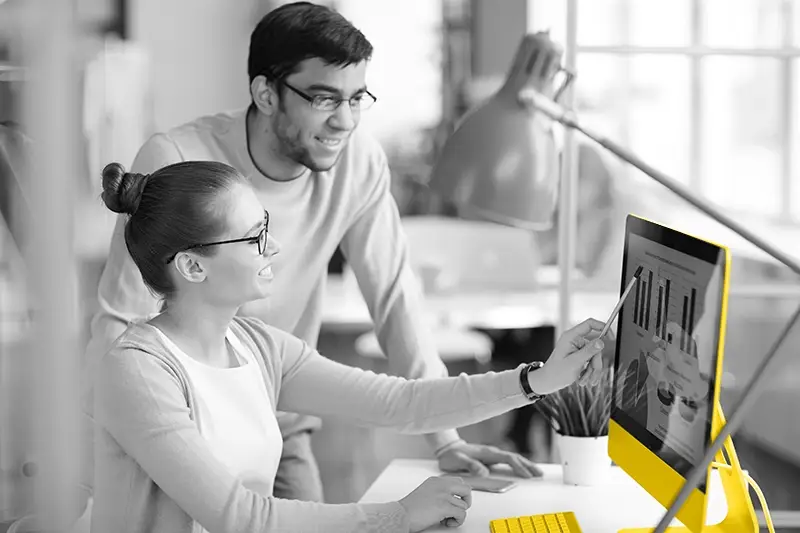 Two people looking at a yellow computer screen