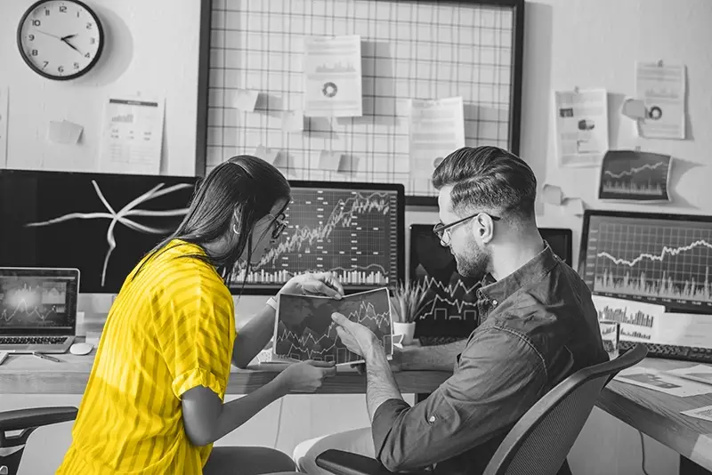 Image of two people looking at graphs