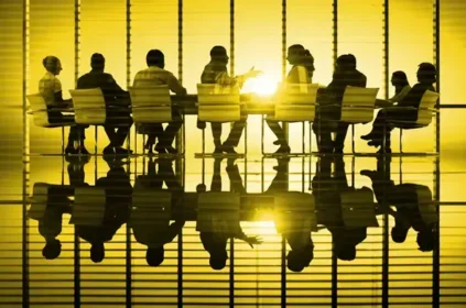 Conference room meeting in a golden room with the people in shadow