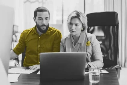 Man and woman looking at laptop in an office