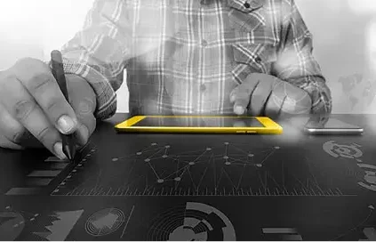 Man looking at a yellow tablet and drawing graphs