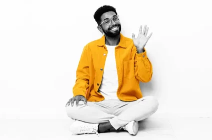 Man sitting cross-legged, waving good bye