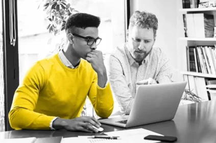 Two guys looking at a laptop