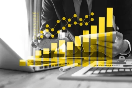 Yellow bar graph overlayed on black and white photo of hands and a laptop