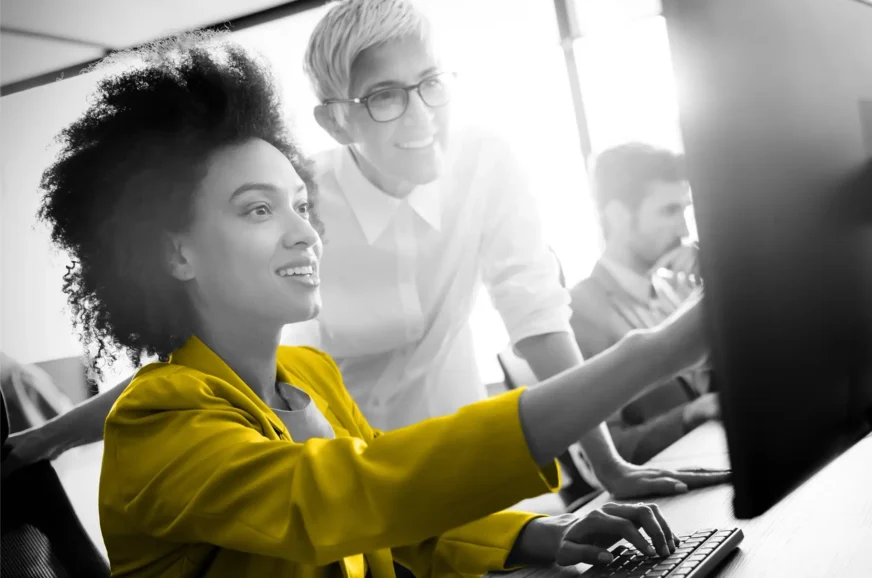 Two women looking at a computer and smiling